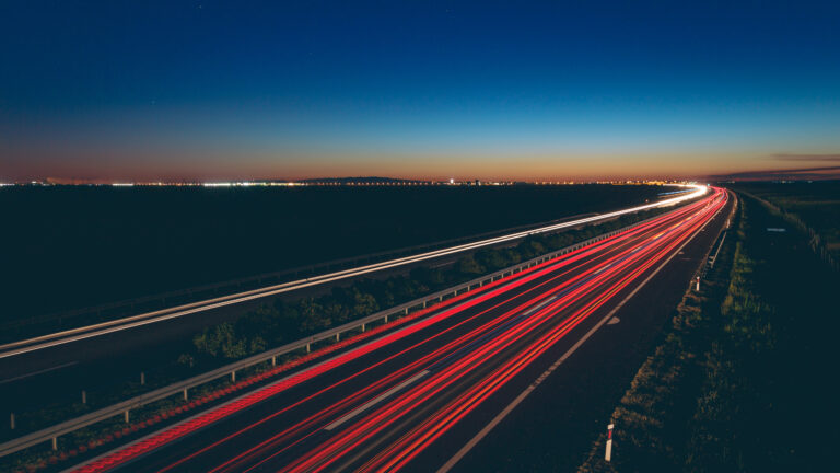 Transport routier de nuit sur une route éclairée, illustration du droit des transports